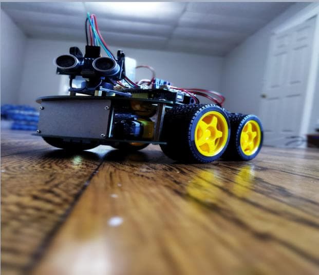The four-wheeled autonomous mobile robot with ultrasonic sensor on a floor